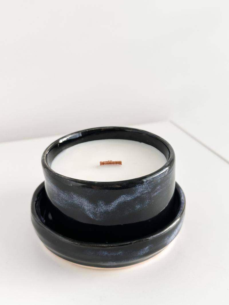Black glazed ceramic candle on a matching saucer