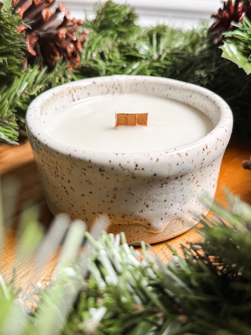 Speckled bowl candle nestled in pine garland