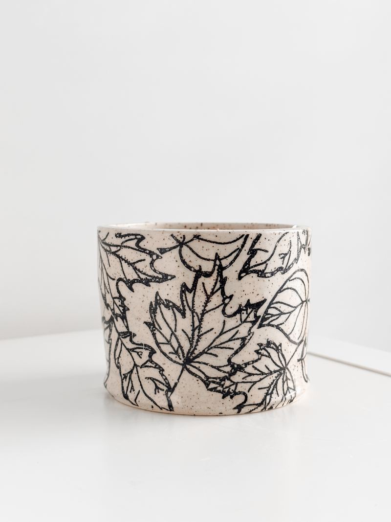 Cream ceramic candle with hand-drawn black leaves