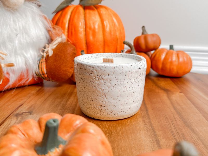 Speckled stoneware candle bowl surrounded by small pumpkins