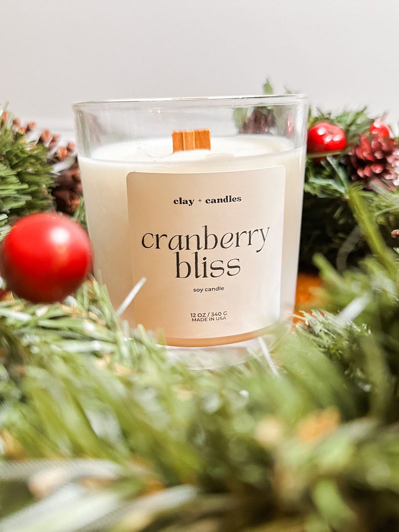Cranberry Bliss candle tucked into pine garland with red berries