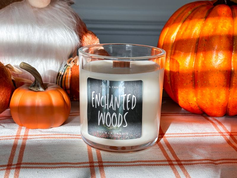 Enchanted Woods candle with a black lid beside pumpkins