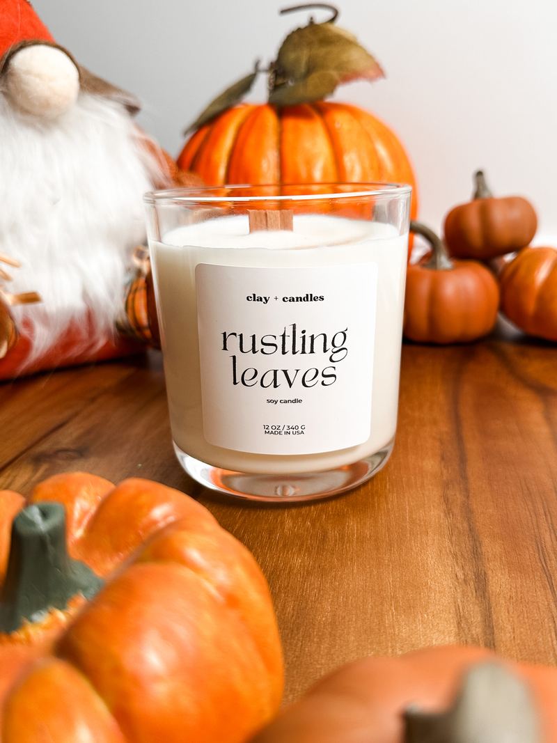Rustling Leaves candle surrounded by small pumpkins