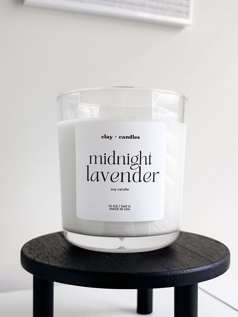 Midnight Lavender candle in a clear glass jar on a black riser