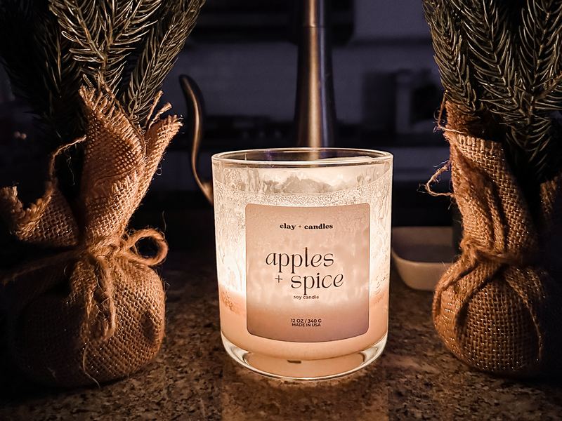 An Apples and Spice candle glowing at night